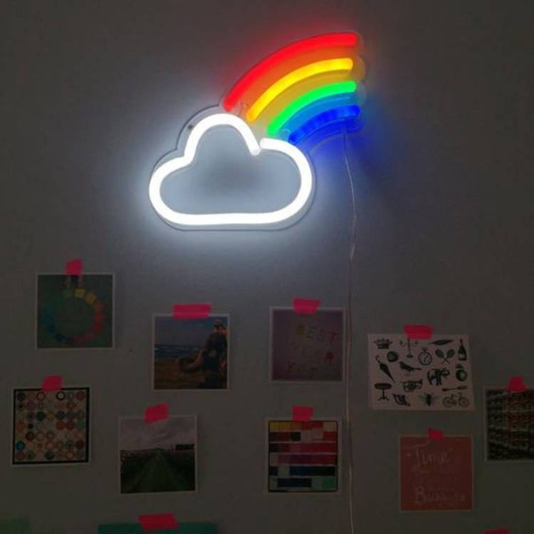 Parede com luminária acesa de nuvem e arco-íris, além de fotos pregadas com fita rosa