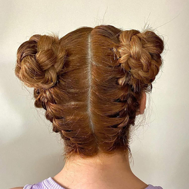 cabelo ruivo com dois coques altos trançados.