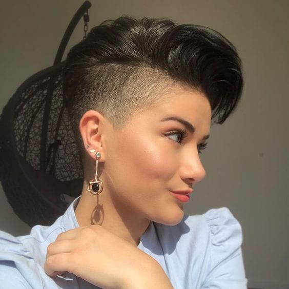 Corte cabelo curto com lateral raspada em mulher, usando roupa azul e brincos