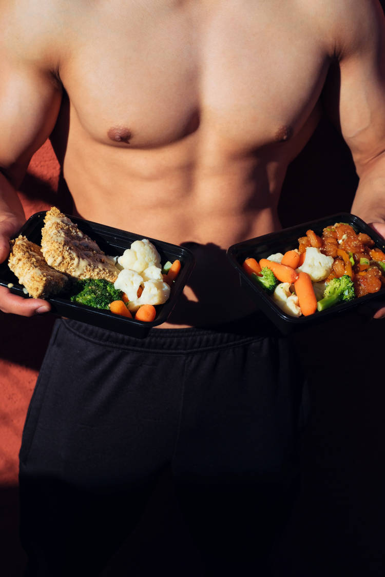 Homem mostrando alimentação pós-treino. Homem malhado comendo depois de treinar.