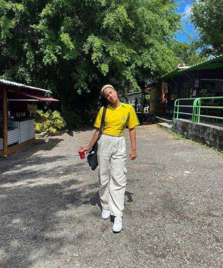 Menina com camiseta do Brasil, calça jogger, tênis branco e faixar no cabelo