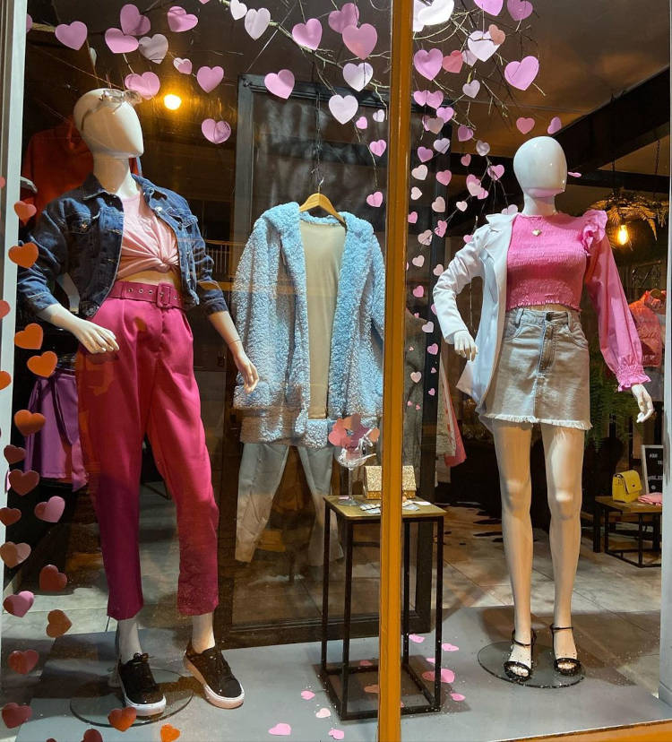 Vitrine de Dia das Mães decorada com corações de papel rosa.