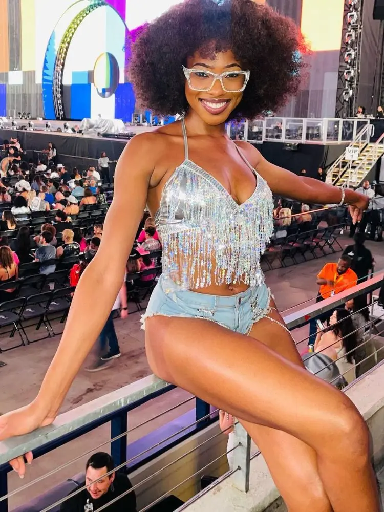 foto de mulher negra usando top prata com franjas de paetê e hot pants jeans