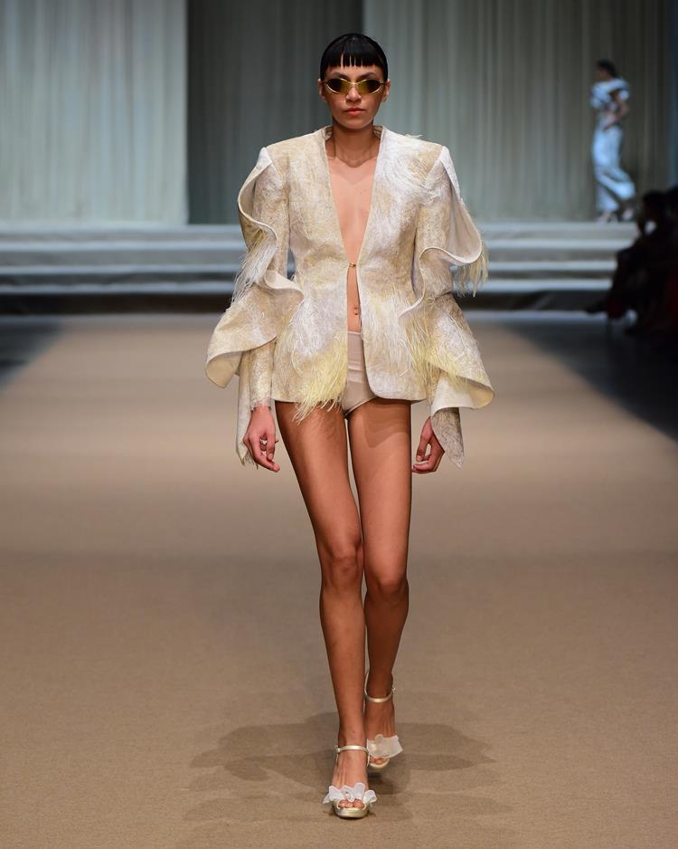modelo no desfile Melk Z-Da com blazer branco e amarelo e óculos escuros
