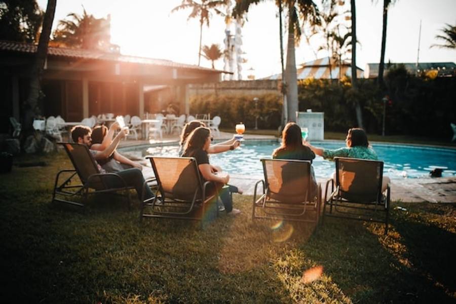 Amigos brindando na beira de piscina de hotel em Fernando de Noronha