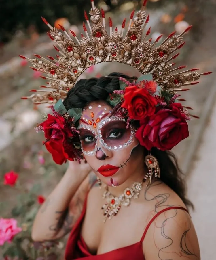Foto de mulher usando tiara de Halloween dourada com flores de caveira mexicana