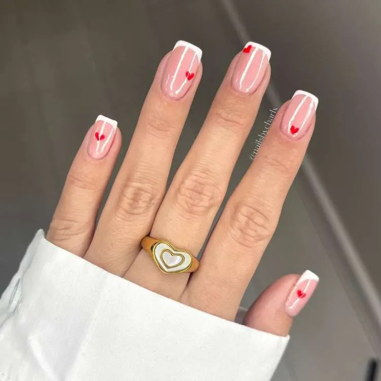 Unhas rosas decoradas com corações vermelhos e francesinha branca