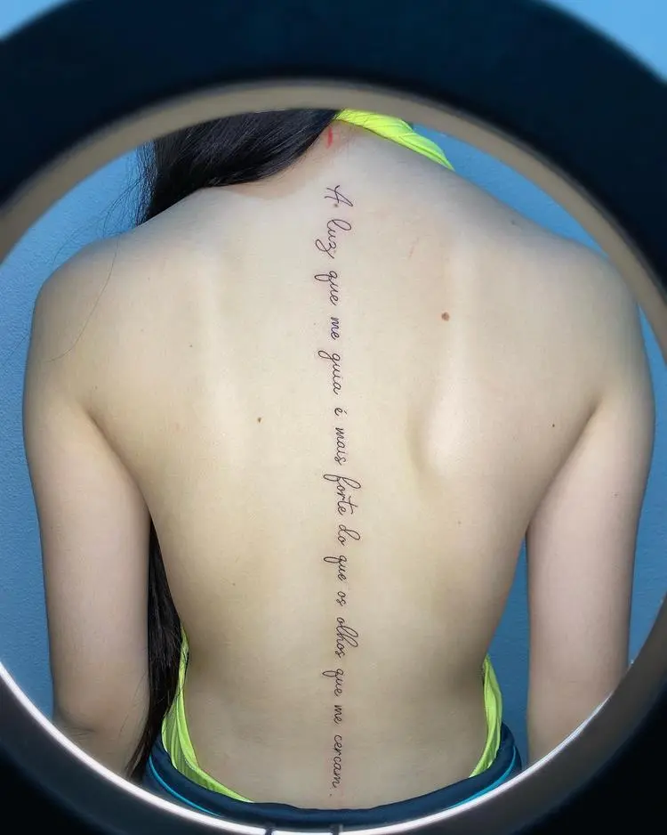 tatuagem escrita A luz que me guia é mais forte do que os olhos que me cercam nas costas