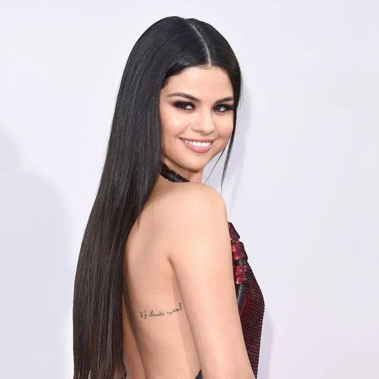 Selena Gomez com tatuagem na parte de trás da costela em árabe