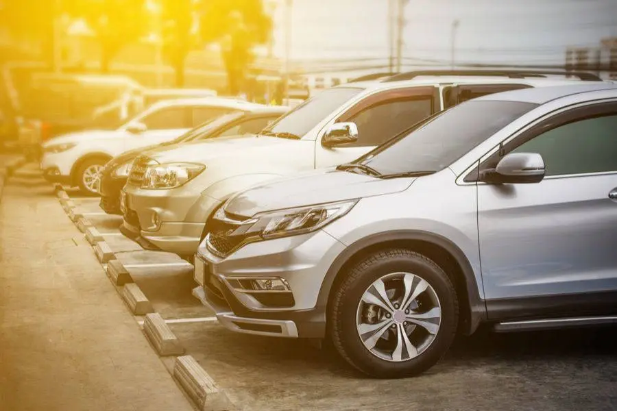 Frota de carros de marcas como honda e toyota parados em um estacionamento. Há uma mancha amarela no canto superior direito da imagem