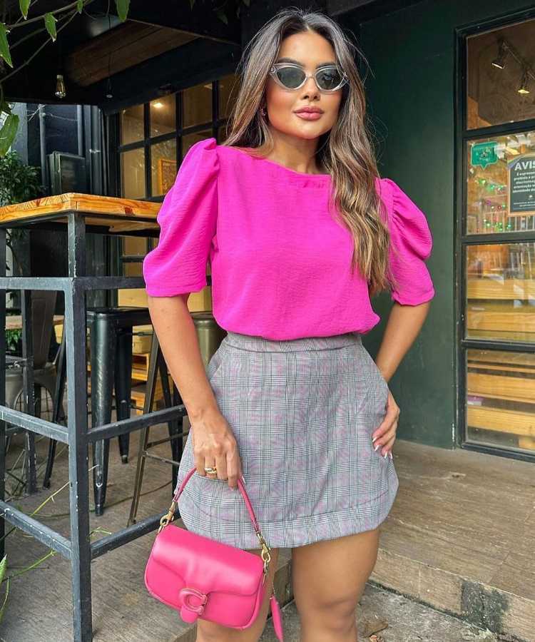 Mulher com blusinha pink + saia xadrez + bolsa pink