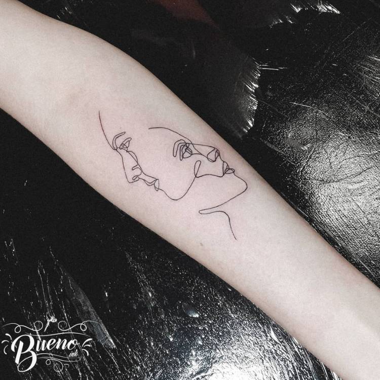 Tatuagem feminina de dois rostos feitos com apenas um traço contínuo