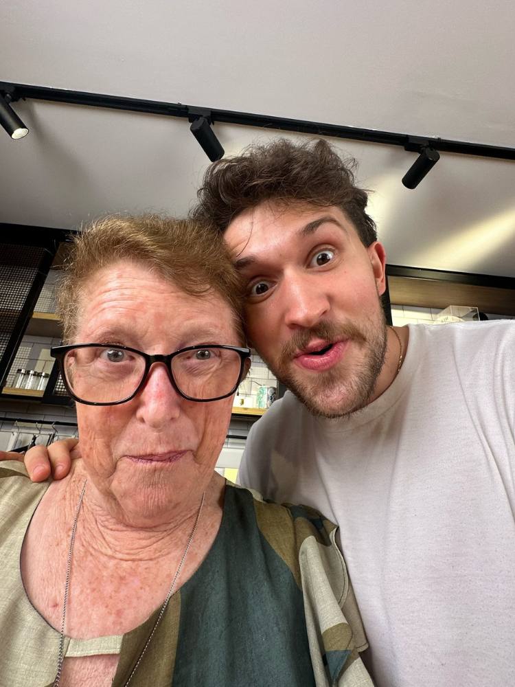Senhora de pele clara usando roupa verde ao lado de Cheff Otto de camiseta branca