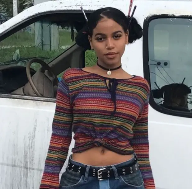 look anos 2000 blusa nó, calça cintura baixa e cabelo amarrado com palito