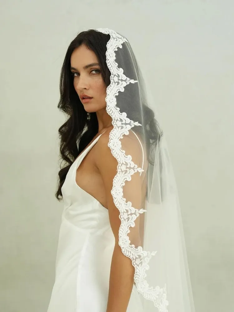 Noiva de pele clara de vestido slim e véu mantilla