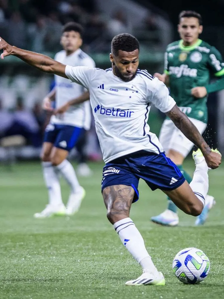 Wesley, do Cruzeiro, chutando a bola com Raphael Veiga, do Palmeiras, atrás.