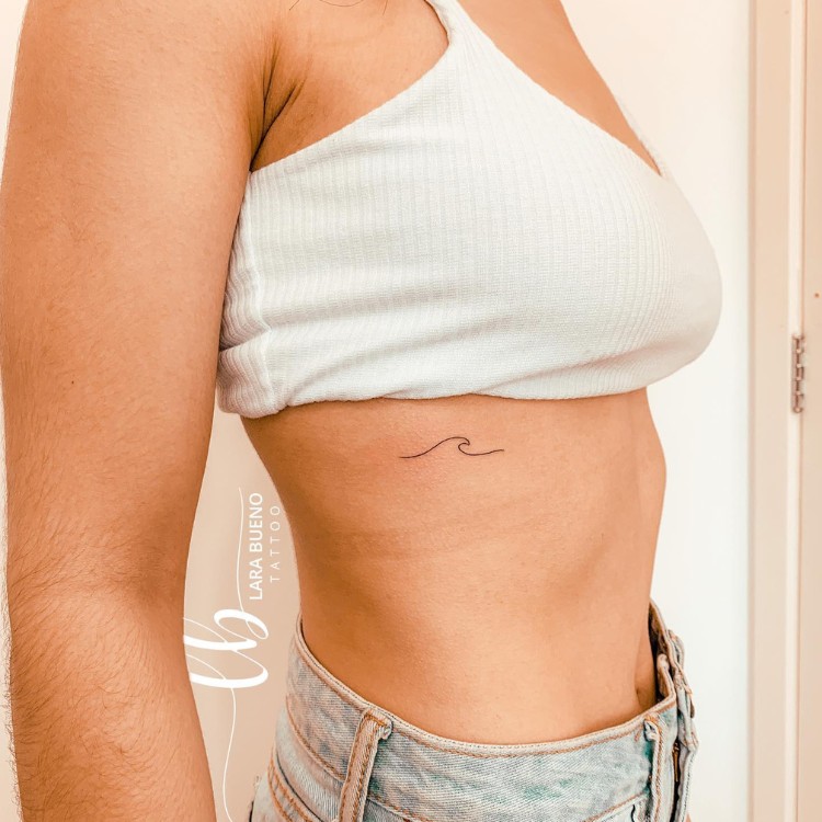 Tatuagem pequena em fineline de onda na costela 