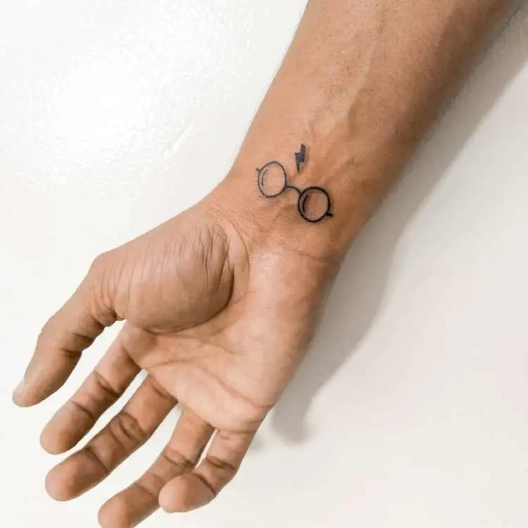 tatuagem no pulso com referência ao Harry Potter (óculos e cicatriz de raio)