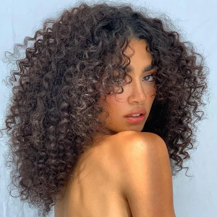 mulher de cabelo médio cacheado castanho e franja média