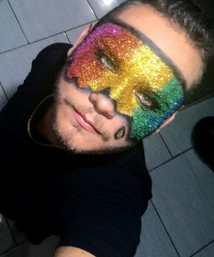 Selfie d ehomem de pele clara com maquiagem de máscara colorida de glitter