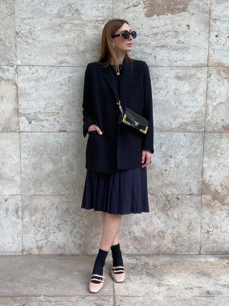 mulher usando look todo preto com sapato de boneca bege de verniz com 2 fivelas