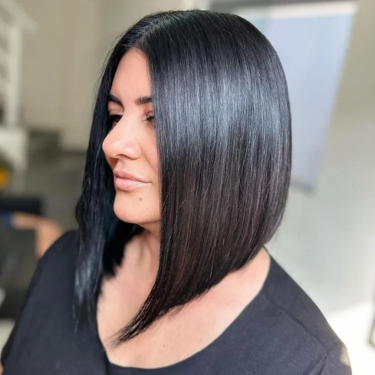 Mulher de pele clara de roupa preta e cabelo preto em chanel de bico 