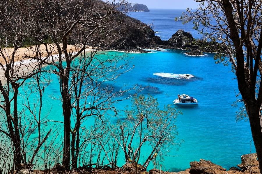 vista aérea do mar de Fernando de Noronha com barco navegando