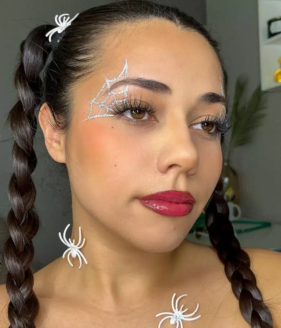 Mulher de pele clara usando maquiagem de um delineado prateado que simula teia de aranha