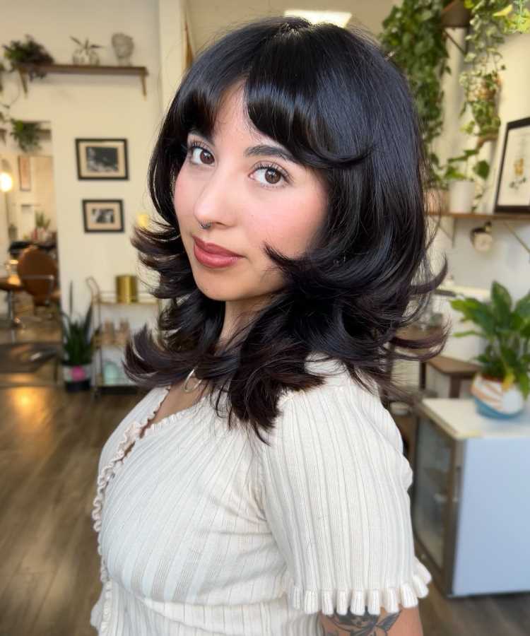 A imagem mostra um corte de cabelo conhecido como "Shag Haircut" com a técnica repicado. Esse estilo é caracterizado por camadas desfiadas que adicionam textura e volume. A franja cortina complementa o visual, proporcionando um toque moderno e despojado.


