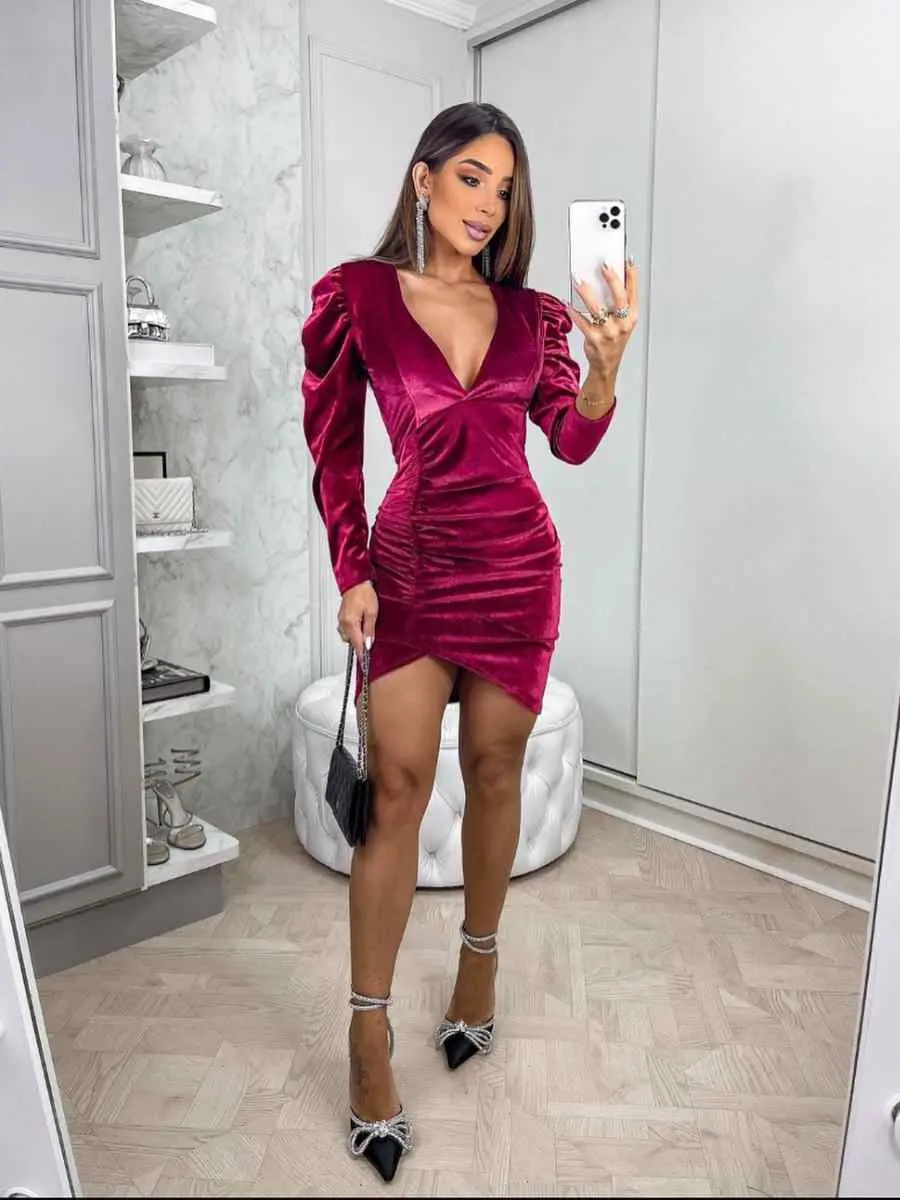 Mulher usando look vermelho-escuro para o Natal composto por vestido de camurça curta.