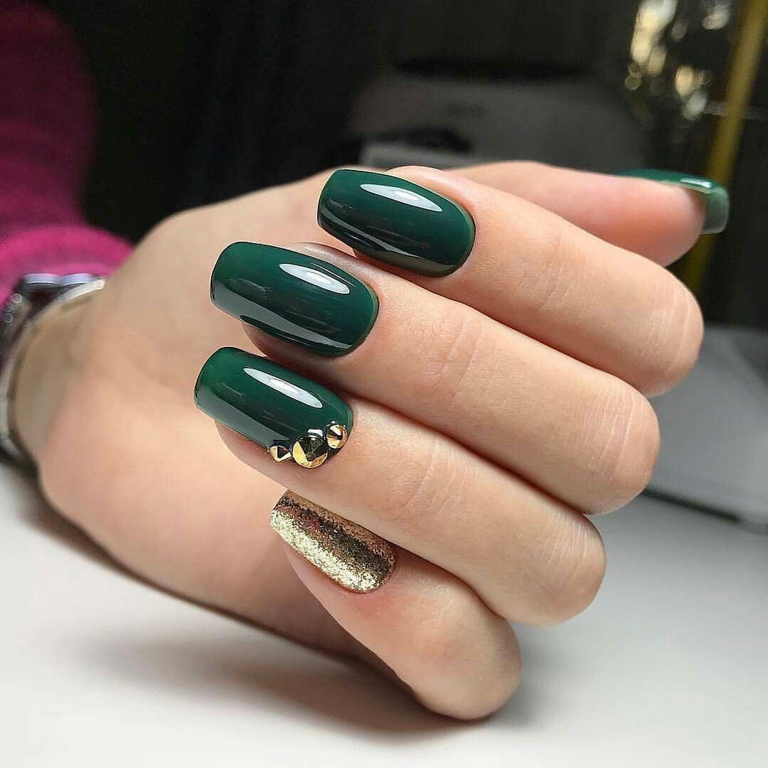 Unhas verdes e dourado com pedras.