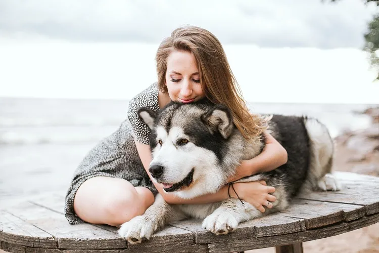 mulher abraçando cachorro