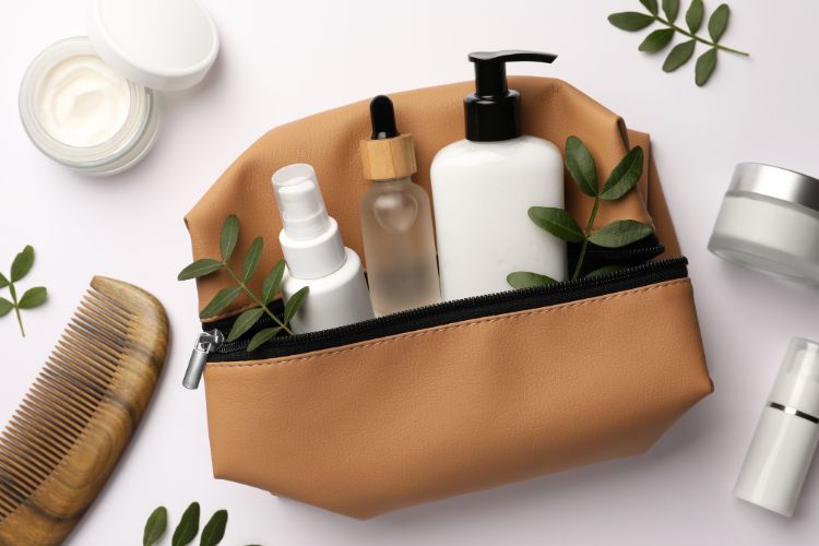 Nécessaire decorada com folhas e com kit spa de presente de Dia das Mães dentro, com pente de madeira, hidratante facial e labial, tônico, óleo hidratante e máscara capilar