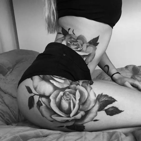 Tatuagem grande rosa pegando cintura e quadril