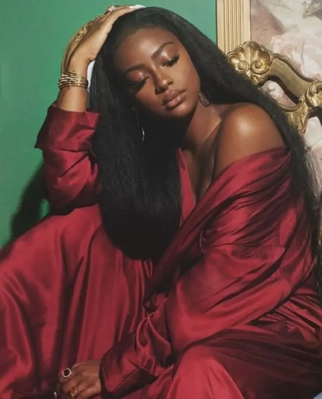 Frase para foto pensativa mulher negra com cabelos longos e manto vinho Frase para foto pensativa mulher negra