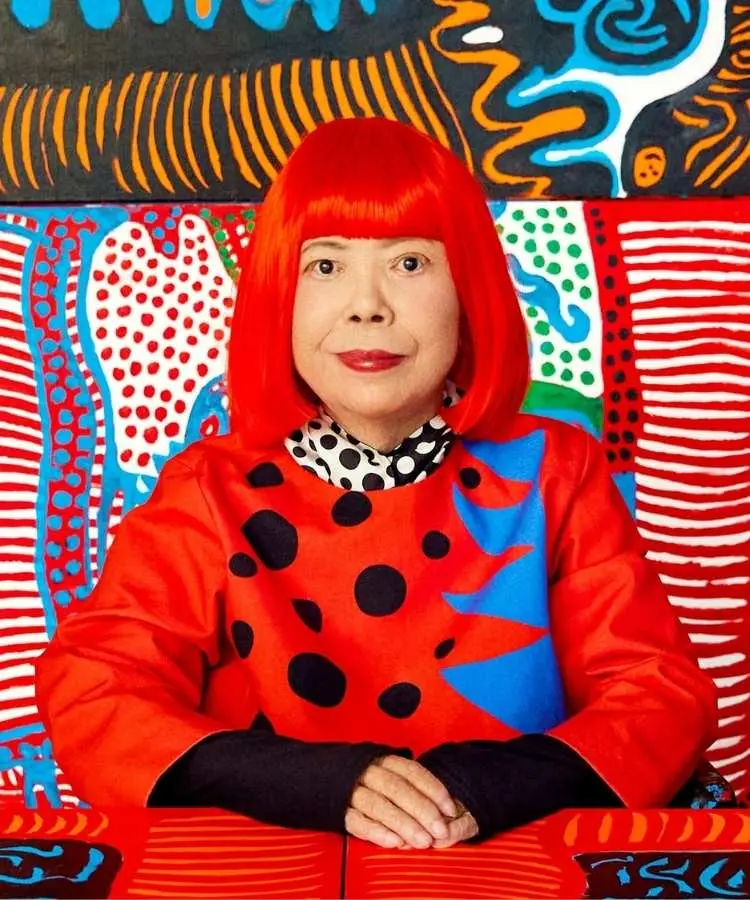 Foto de Yayoi Kusama em frente a uma de suas pinturas