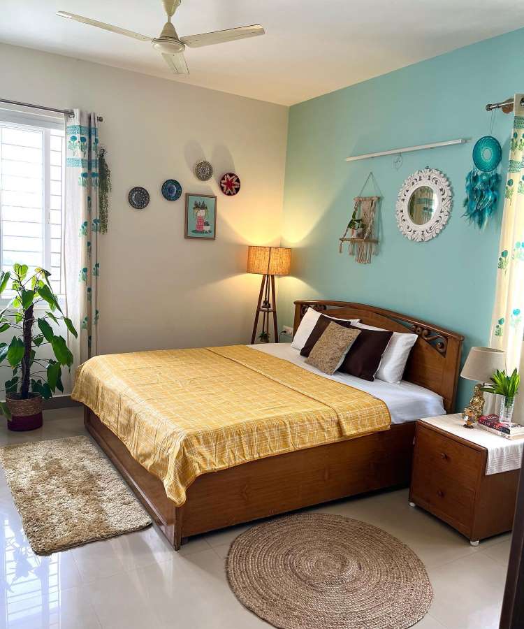 Quarto de casal com espelho redondo moldura de madeira. Cores predominantes: amarelo, azul, madeira, plaha