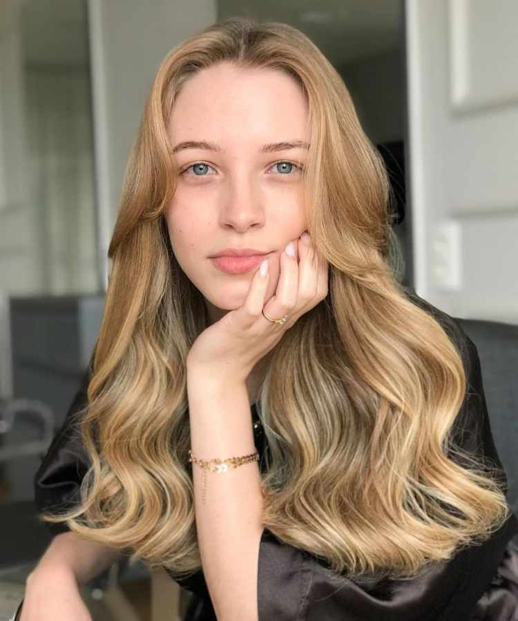 Corte de cabelo longo com franja curtain bangs.
