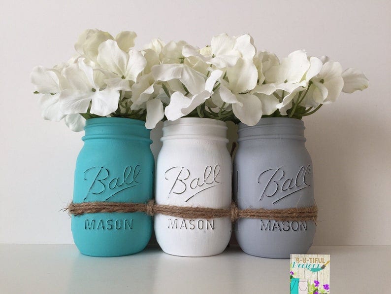 3 potes de vidro com flores brancas 