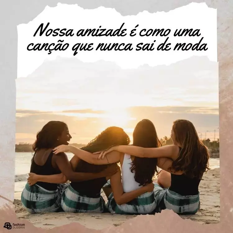 Imagem de quatro amigas de costas se abraçando. Elas são de diferentes tons de pele e tem cabelos escuros. Três delas usam blusa preta e uma delas usa blusa branca. Todas estão sentadas na areia de uma praia. Acima da foto, há a frase "Nossa amizade é como uma canção que nunca sai de moda" em um bloco branco.