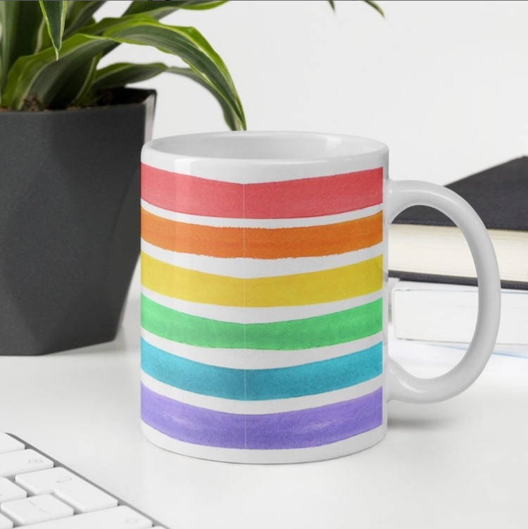 Caneca de fundo branco com as cores da bandeira LGBTQIA+.