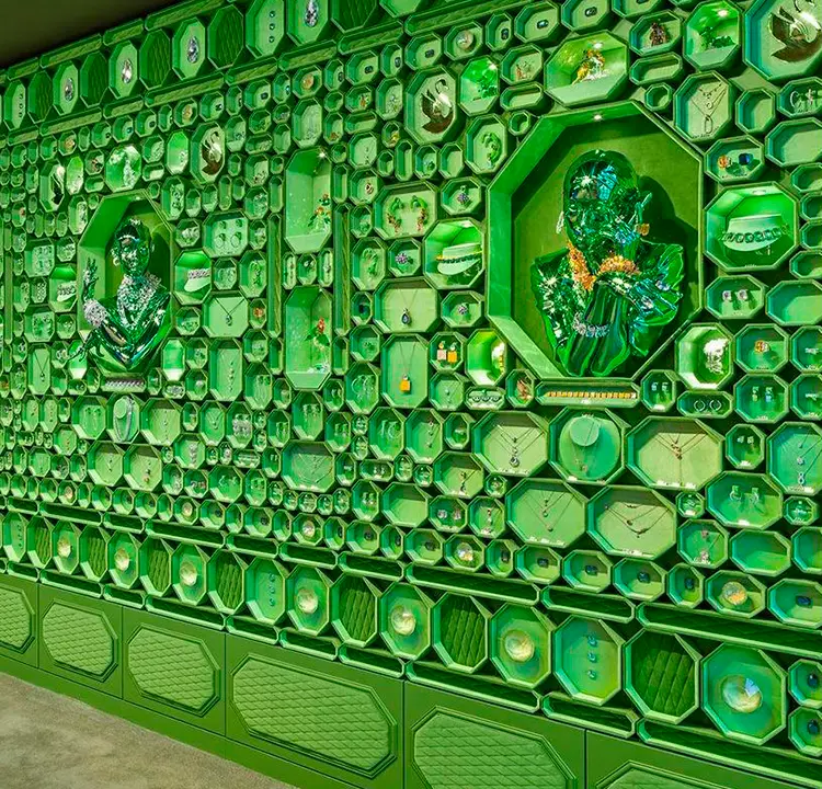 Layout da parede da loja nova da Swarovski. Cheia de texturas e formatos, tudo em verde.