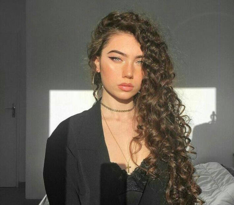 Mulher de pele clara com cabelo cacheado solto