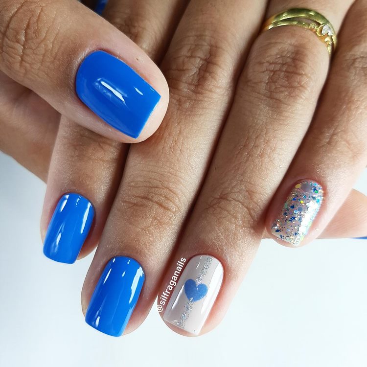 Unha azul-médio com decoração de coração e com glitter