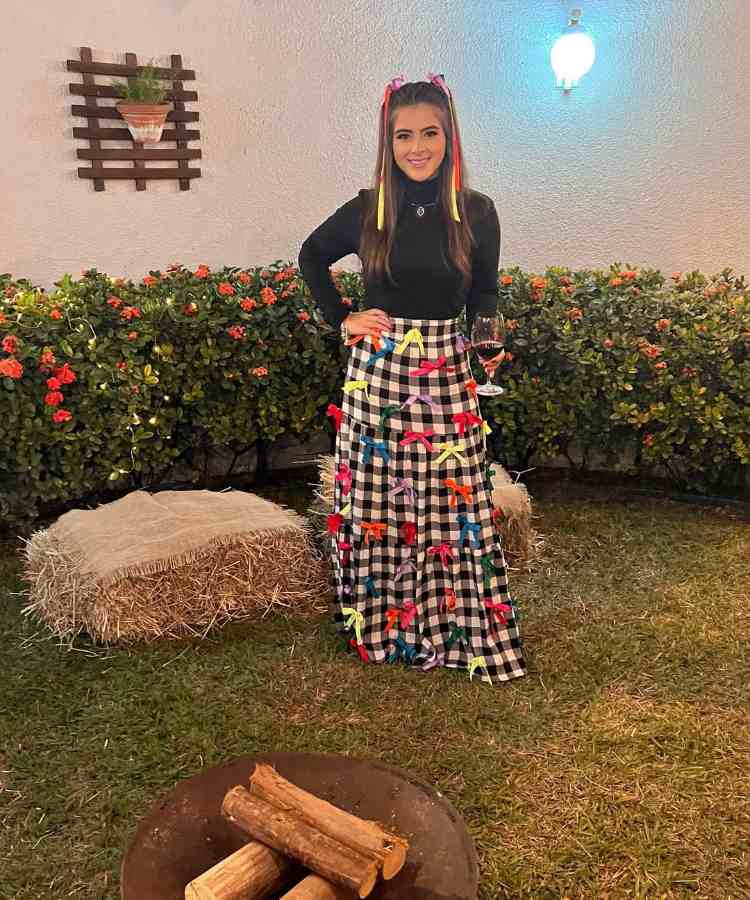 Mulher com saia longa xadrez enfeitada com laços de fita