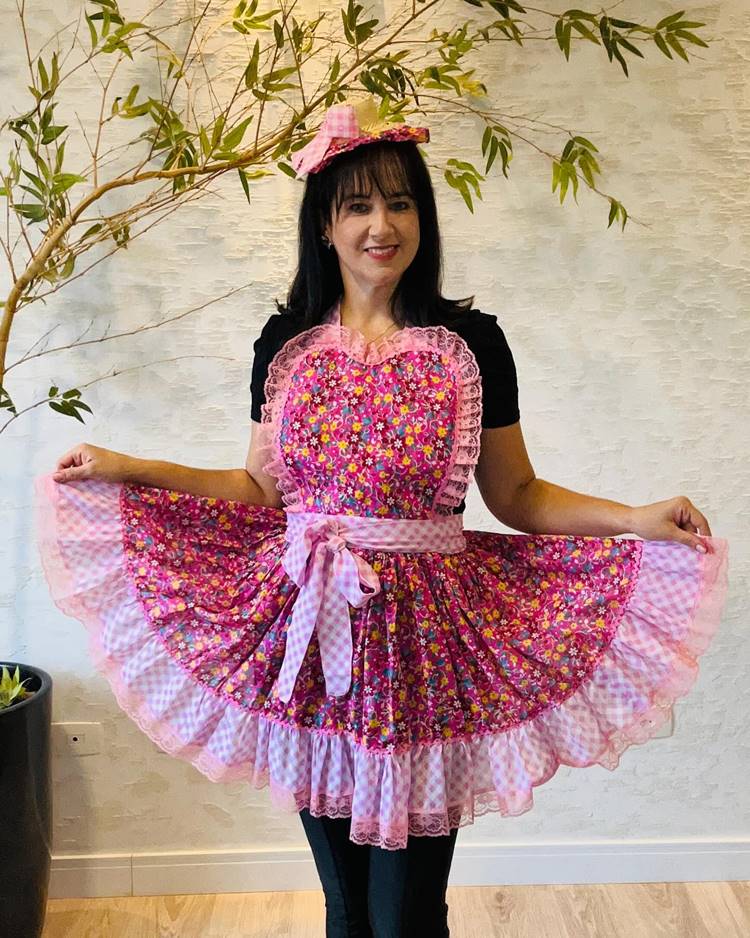 Mulher com vestido florido e xadrez cor de rosa