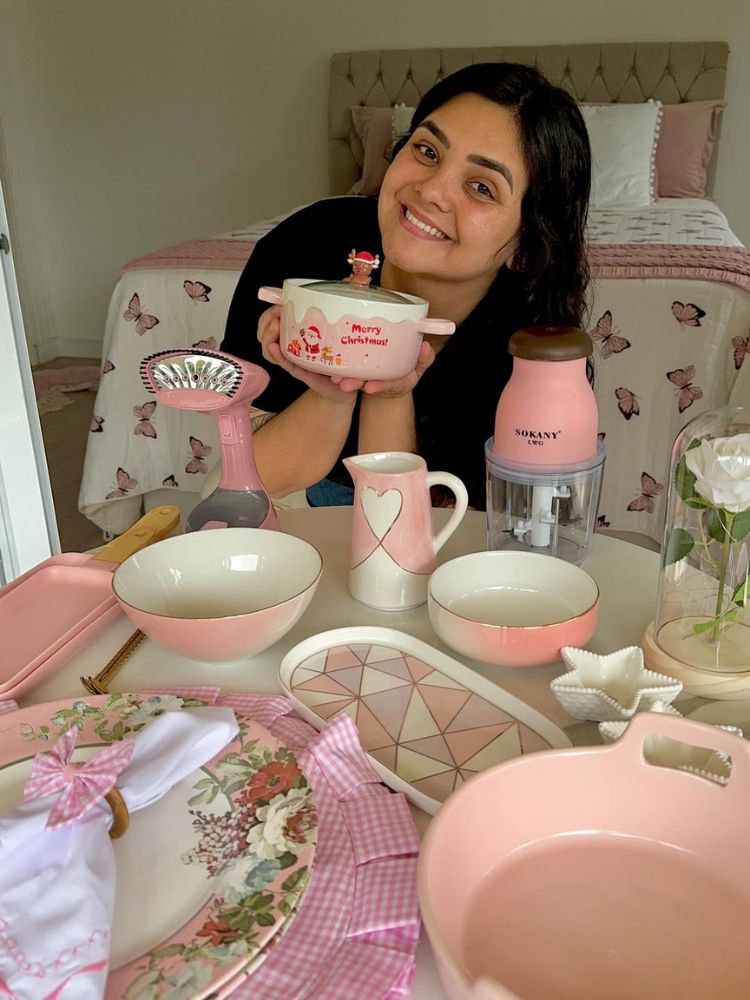 Bianca Targa de roupa preta mostrando louças rosas 
