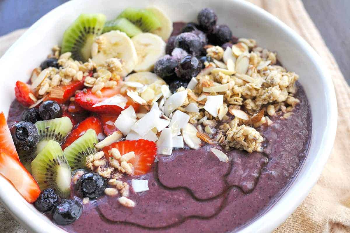 Tigela de açaí com morango, banana, mirtilo, granola, coco e mais