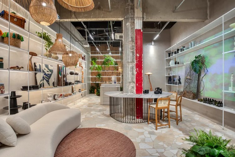 A imagem mostra um interior moderno e estiloso, com mobiliário contemporâneo, plantas, iluminação suave e uma paleta de cores neutras.

