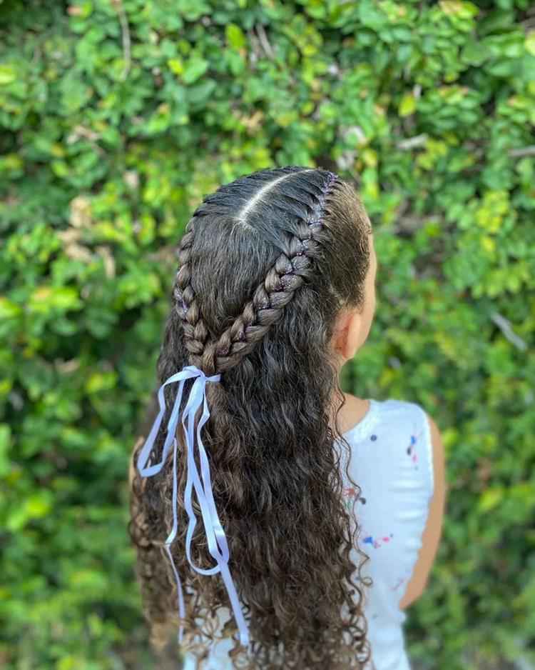 menina de costas com cabelo meio preso, laterais com trança e o resto solto